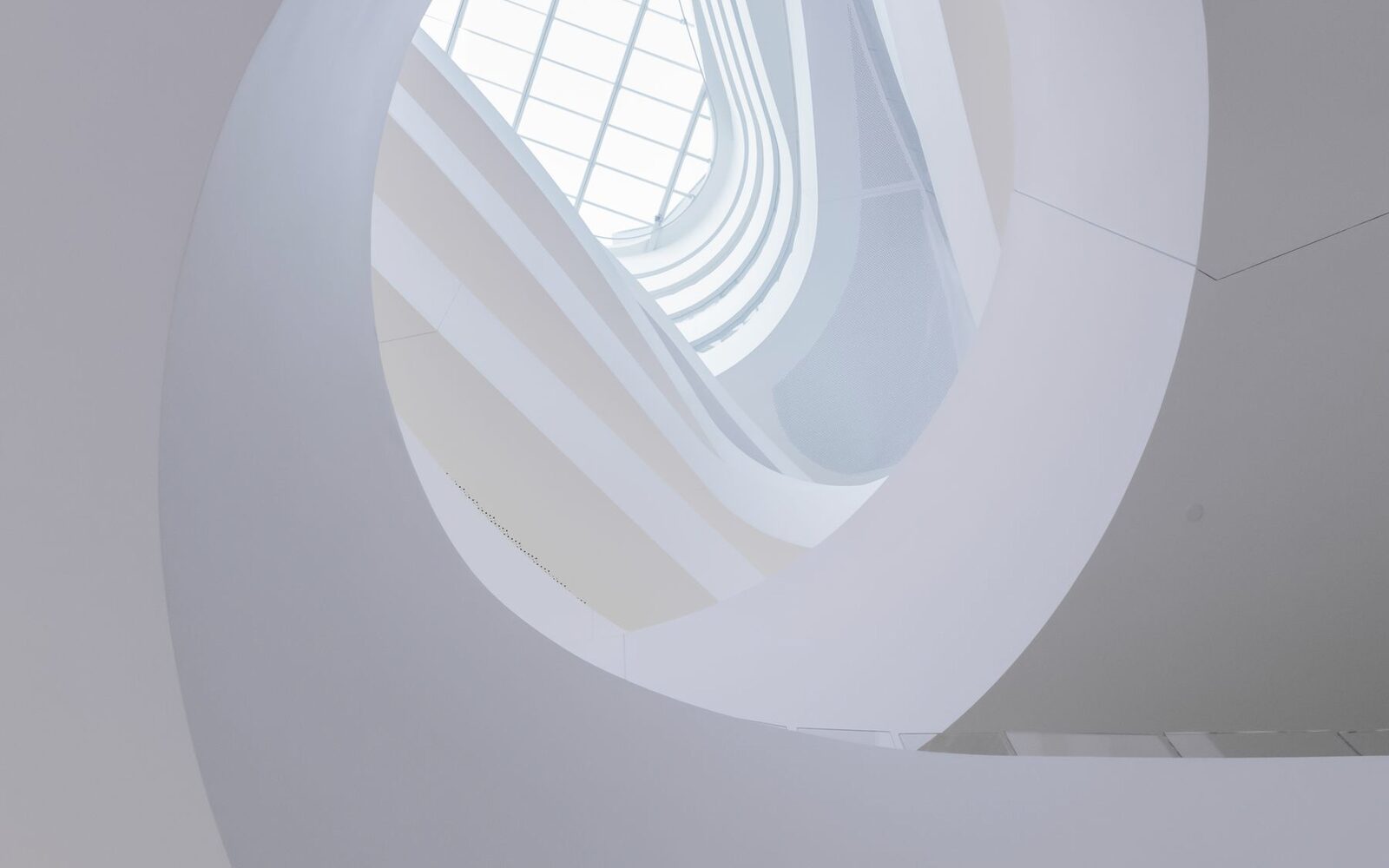 Escalier hélicoïdal blanc vu d'en bas, métaphore de l'approfondissement