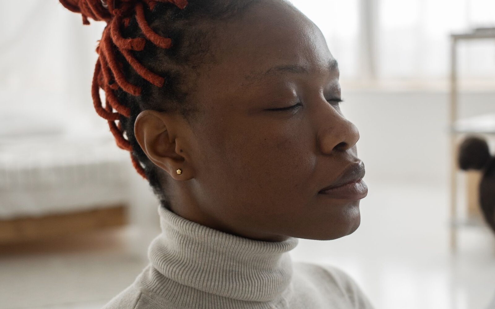Femme assise chez elle, les yeux fermés, en pleine attention intérieure