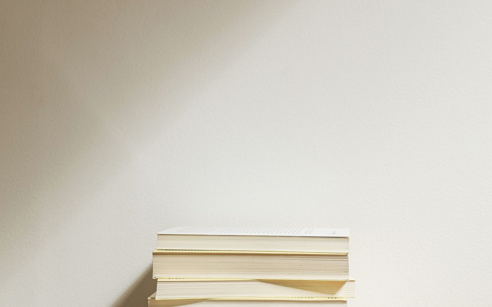 Petite pile de livres posée contre un mur clair